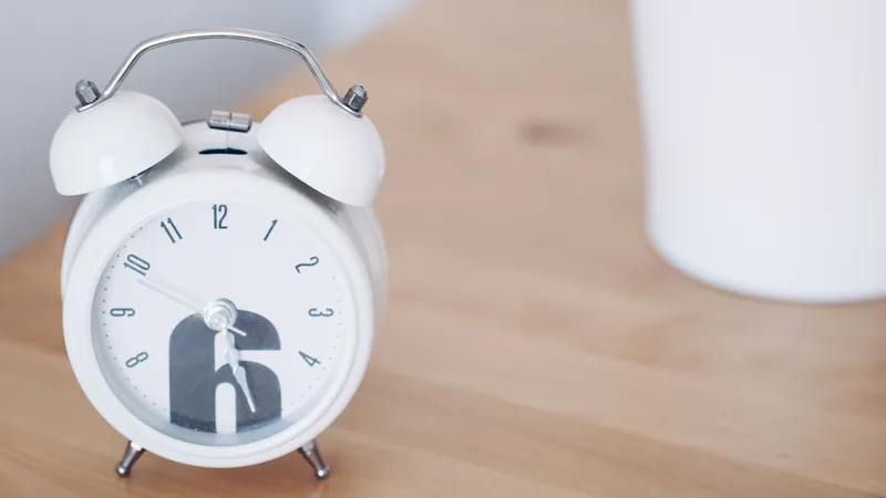 White alarm clock on a wooden shelf