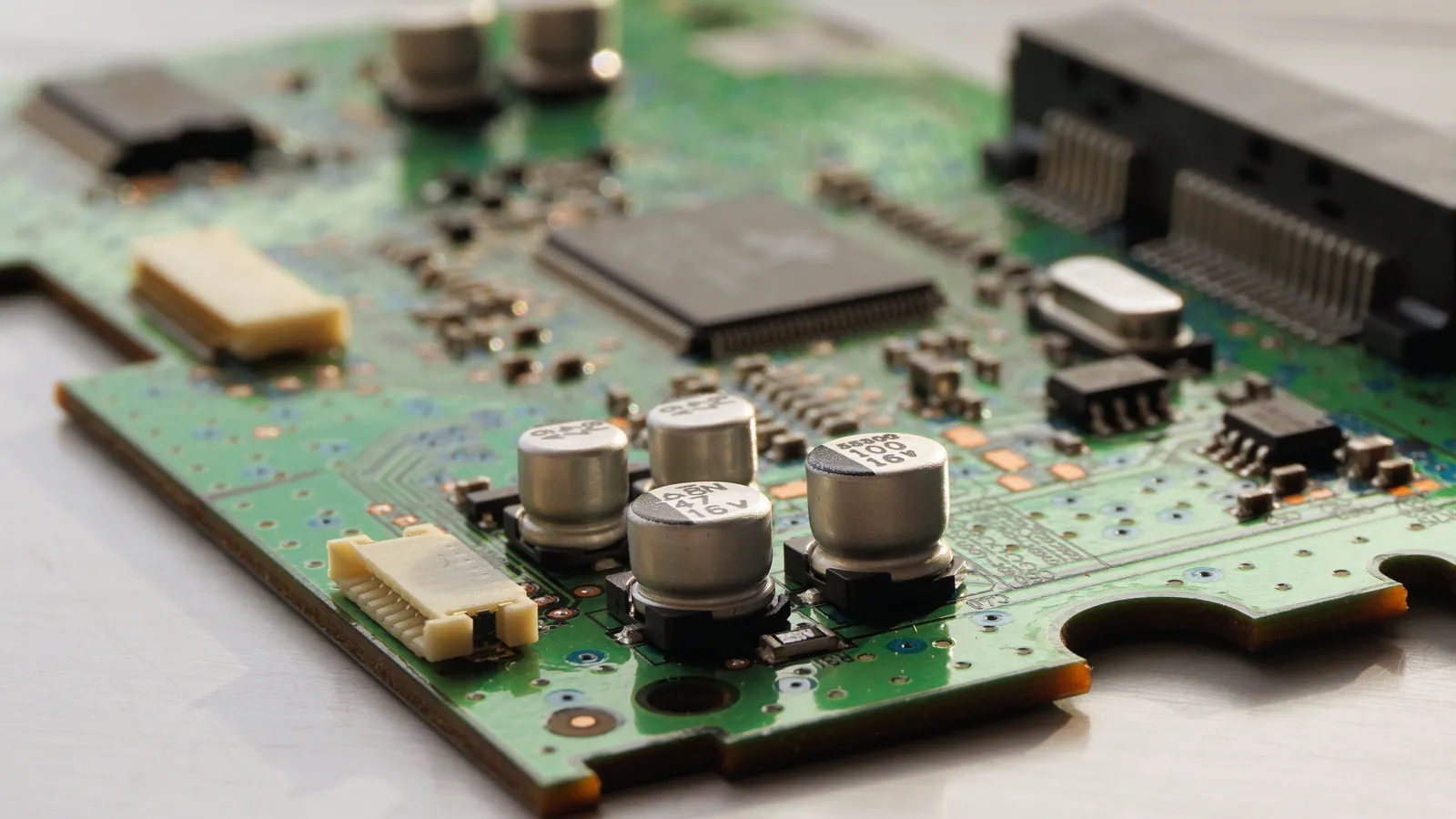 Green circuit board with microchips and capacitors